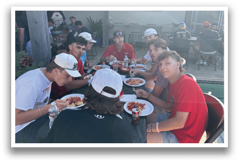 A group of people are sitting around a table eating pizza. AI generated content
