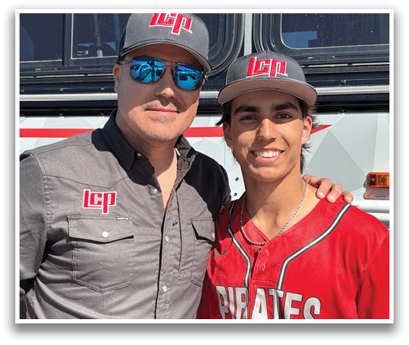 Two men are standing next to a bus, one wearing a Pirates jersey. AI generated content