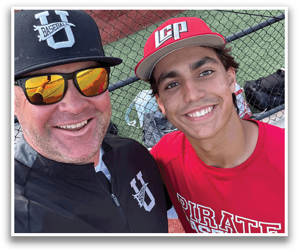 Two men are standing on a baseball field, one wearing a red shirt and the other wearing a black shirt. They are smiling and posing for a picture. AI generated content