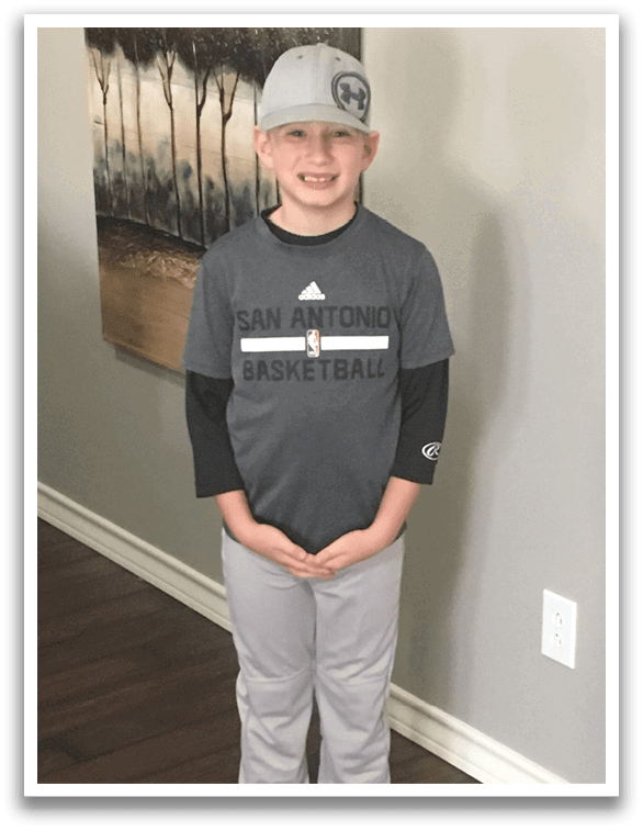 A young boy wearing a basketball shirt and hat stands in a room. AI generated content