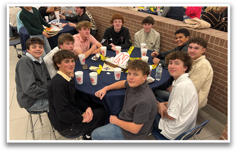 A group of young men are sitting around a table, posing for a picture. They are wearing shirts and ties, and there are cups and bottles on the table. Contenido generado con IA