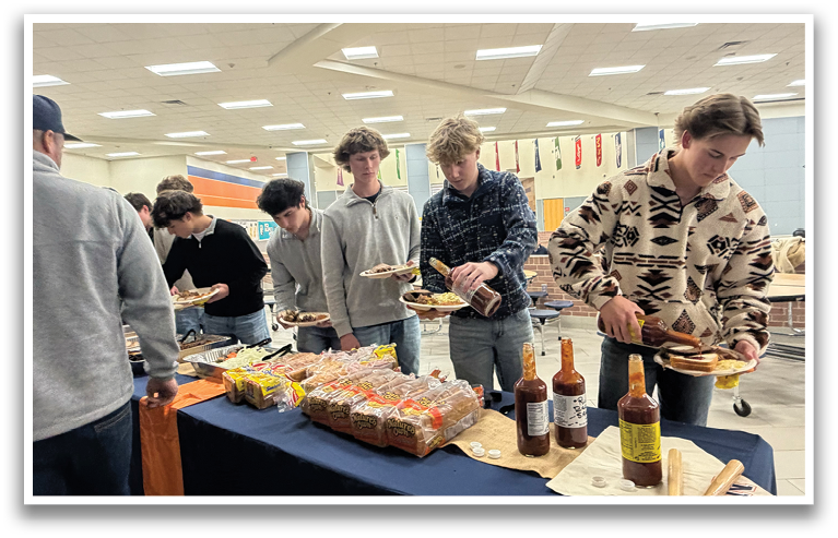 A group of people are gathered around a table with food and drinks. They are eating and drinking from the table. Contenido generado con IA