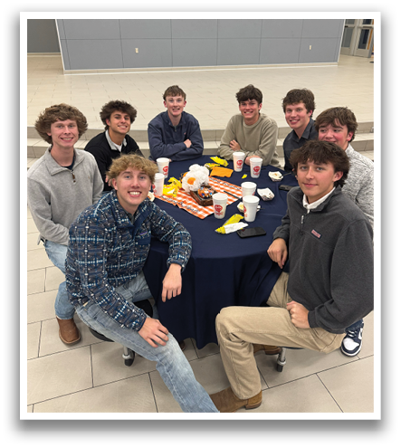 A group of young men are sitting around a table, posing for a picture. They are wearing jeans and shirts, and there are cups and bowls on the table. Contenido generado con IA