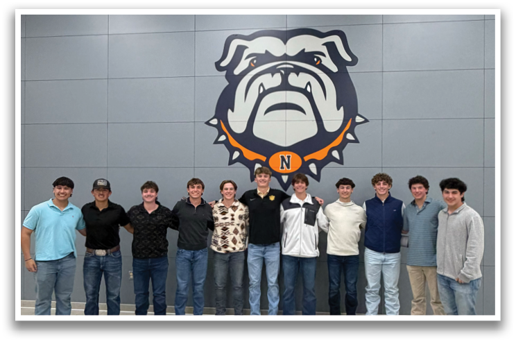 A group of people pose for a picture in front of a wall with a bulldog mascot. Contenido generado con IA