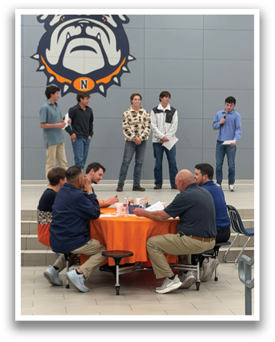 A group of people are standing in front of a table with a logo on it. Contenido generado con IA