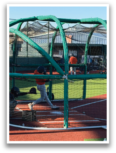 A baseball player is swinging a bat in a batting cage. Contenido generado con IA