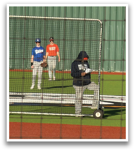 Two men are standing next to a baseball field, one of them holding a baseball glove. Contenido generado con IA
