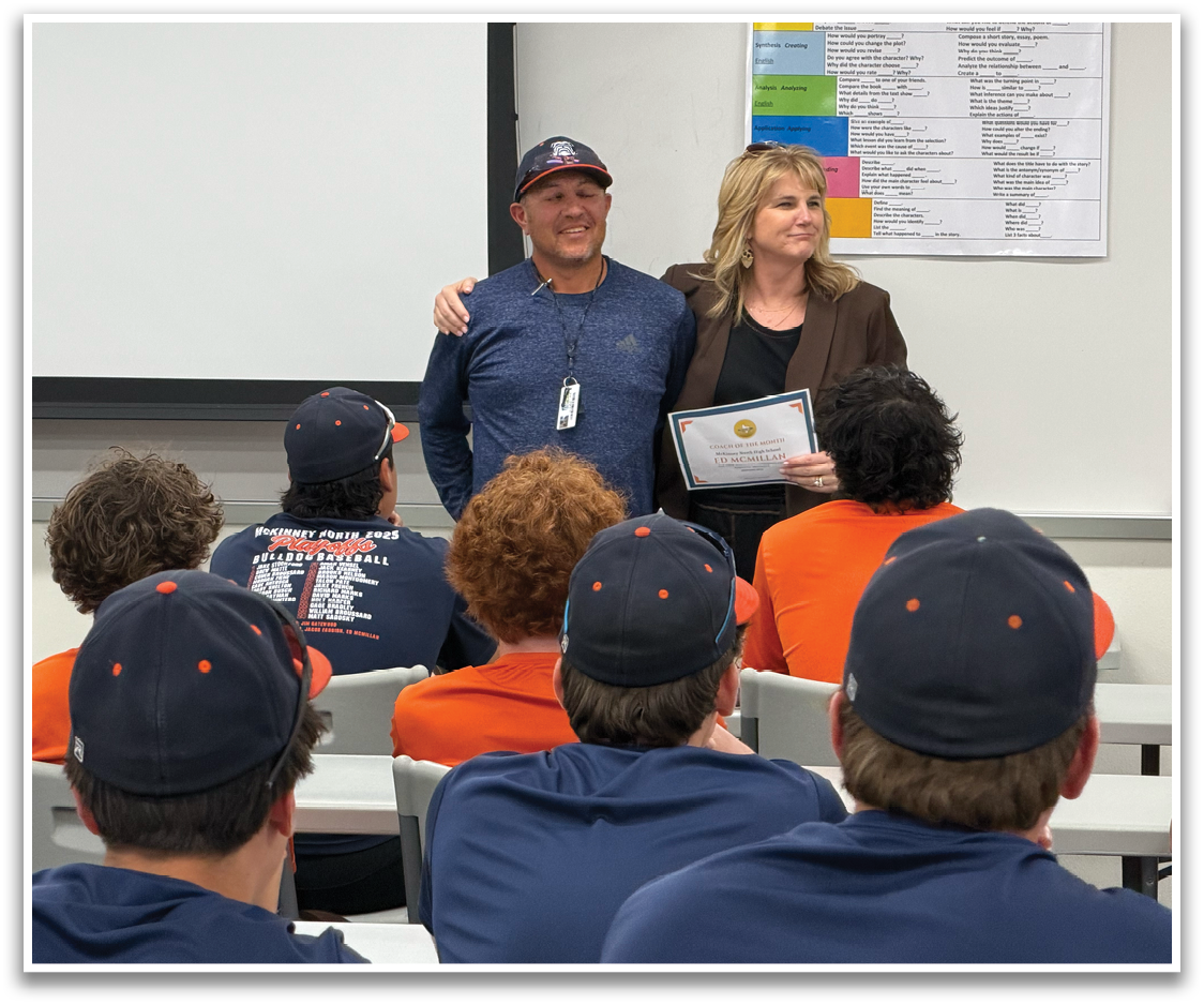 A man and woman stand in front of a classroom, holding a certificate. The woman is wearing a black jacket. Contenido generado con IA