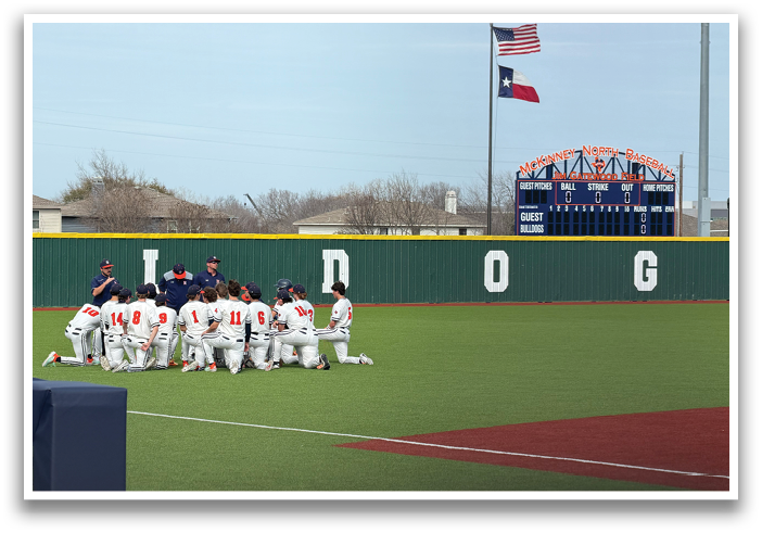 A group of baseball players are sitting on the ground in front of a baseball field. Contenido generado con IA
