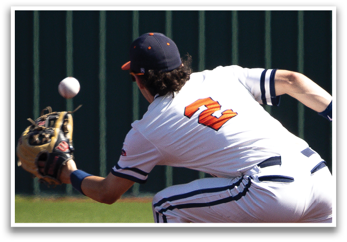 A baseball player in a white uniform is diving to catch a ball. Contenido generado con IA