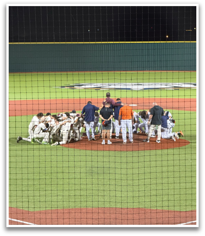 A group of baseball players huddled together on the field. Contenido generado con IA