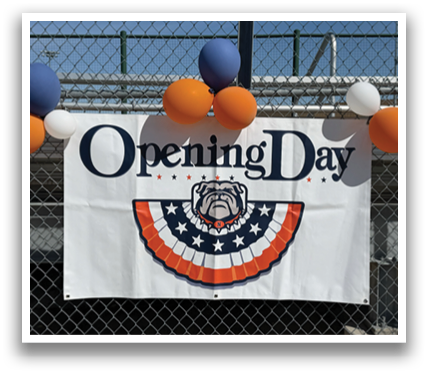 A banner with the words “Opening Day" written on it hangs in front of a fence. Contenido generado con IA