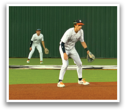 Three baseball players are standing on a baseball field. One player is in the air, possibly jumping to catch a ball. The other two players are standing nearby, watching the action. Contenido generado con IA