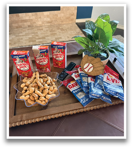A table with a tray of nuts and a box of crackers on it. Contenido generado con IA