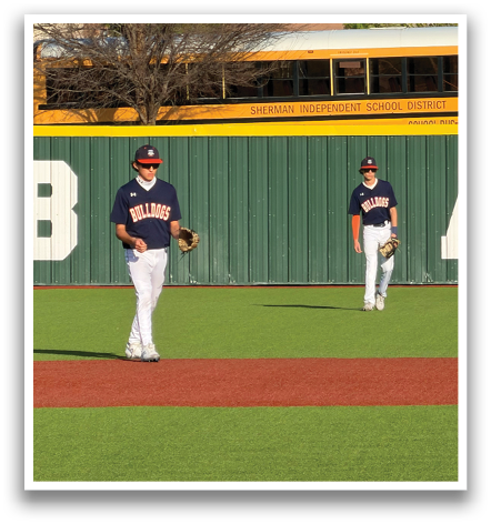 Three people are sitting on a green wall, with one of them wearing a baseball uniform. Contenido generado con IA