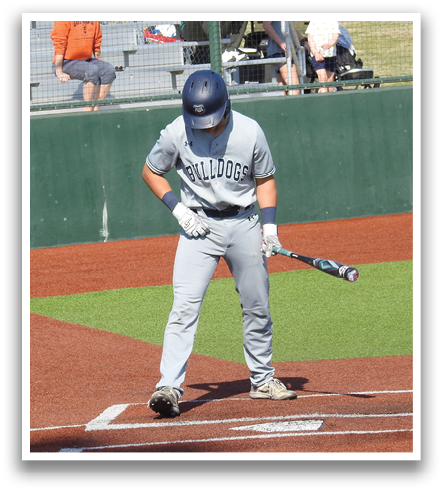 A baseball player is up to bat, holding a bat and preparing to swing. There are several other people in the scene, including a catcher and an umpire, all wearing baseball gloves. A bench is visible in the background, and a golf cart can be seen in the distance. Contenido generado con IA