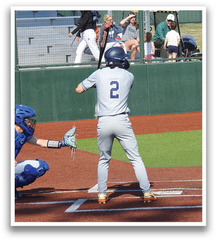 A baseball player is at bat, holding a bat and waiting for the pitch. The catcher is positioned behind him, ready to catch the ball. There are several other people in the scene, some of whom are standing near the fence. A bench can be seen in the background. Contenido generado con IA