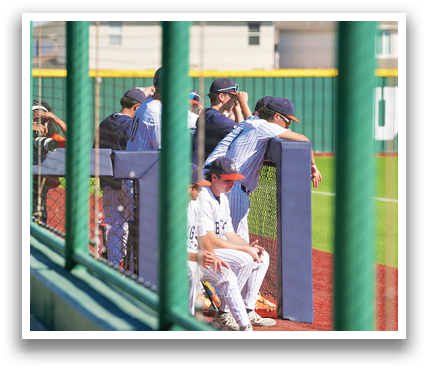 Baseball players sitting on the bench, one of them wearing a red hat. Contenido generado con IA