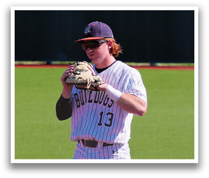 A baseball player wearing a white uniform stands on a field, holding a baseball in his glove. Contenido generado con IA