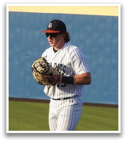 A baseball player wearing a white uniform and a black hat stands on a baseball field. He is holding a baseball glove in his hand. Contenido generado con IA