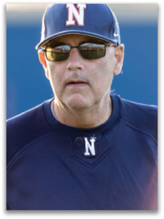 A man wearing a blue baseball cap and sunglasses is standing on a field. Contenido generado con IA