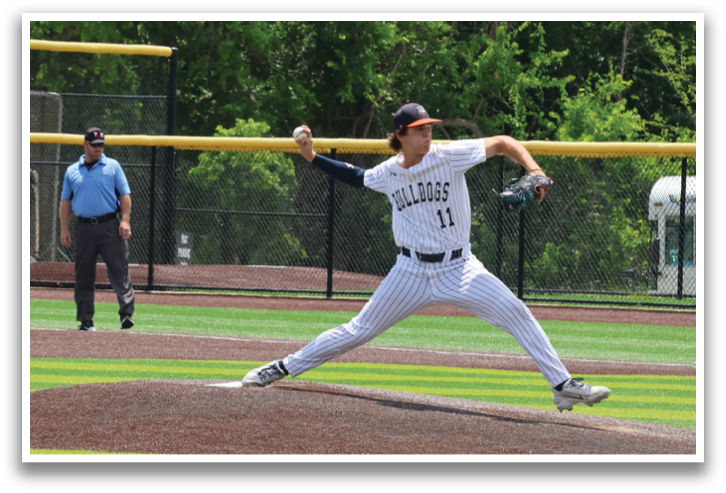 A baseball player is in the middle of a pitch, with his leg in the air. A man in a blue shirt is watching the pitch. Contenido generado con IA