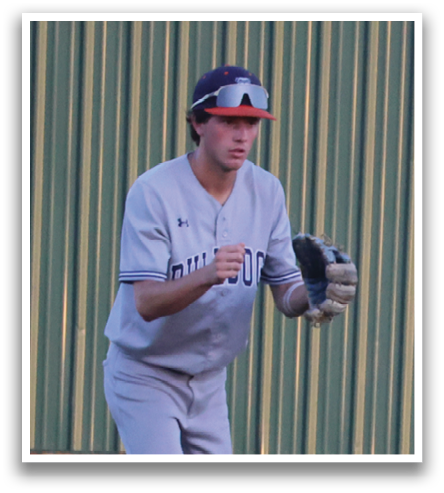 A baseball player in a grey uniform is standing on the field, holding a baseball glove. Contenido generado con IA