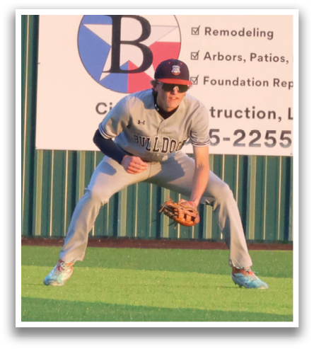 A baseball player is crouching on the field, wearing a blue shirt and red hat. Contenido generado con IA
