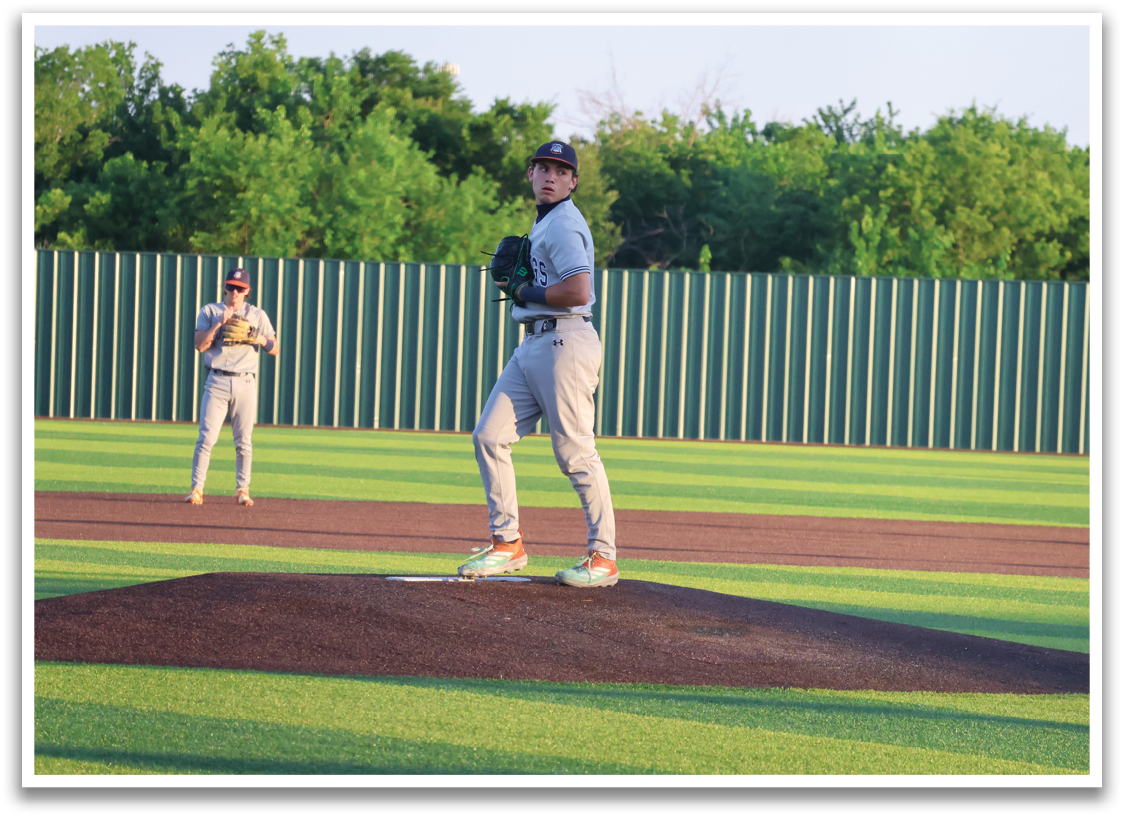 A baseball player is on the mound, wearing a grey uniform and a black hat. He is holding a baseball glove and is in the process of throwing the ball. Contenido generado con IA