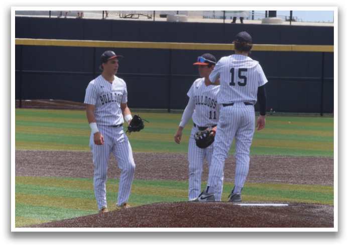 Two baseball players are standing on the pitcher's mound, engaged in conversation. Contenido generado con IA