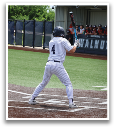 A baseball player is at bat, holding a bat and preparing to swing. The catcher is positioned behind him, wearing a baseball glove. The scene takes place on a baseball field, with a crowd of people watching the game. Contenido generado con IA