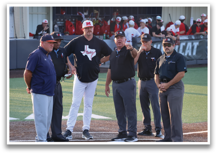 Four men in uniforms are standing on a baseball field, engaged in conversation. Contenido generado con IA