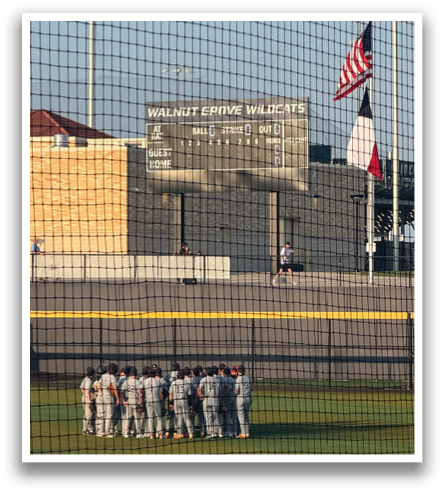 A group of people are standing in front of a baseball field. Contenido generado con IA