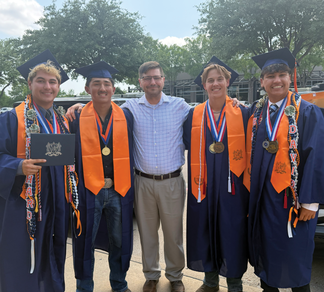 Four men wearing graduation caps and gowns pose for a picture with a man in a suit. Contenido generado con IA