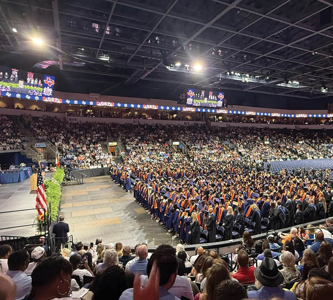 A large crowd of people are sitting in a stadium, watching a graduation ceremony. Contenido generado con IA