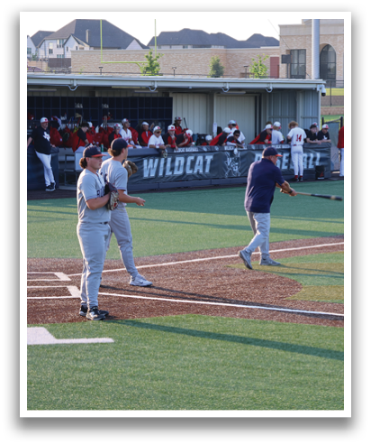 A baseball game is in progress with players on the field. A batter is holding a bat, ready to swing, while a catcher and an umpire are positioned behind him. There are several other players on the field, some of whom are wearing baseball gloves. The scene captures the excitement and anticipation of the game. Contenido generado con IA