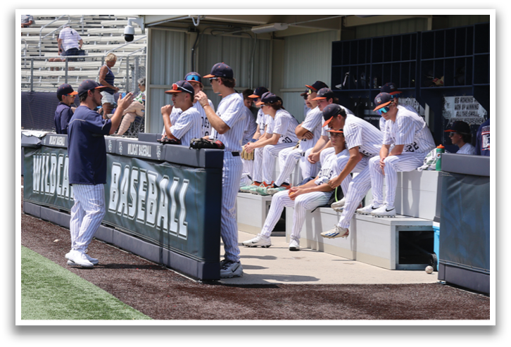 Baseball players are sitting on a bench in the dugout. Contenido generado con IA