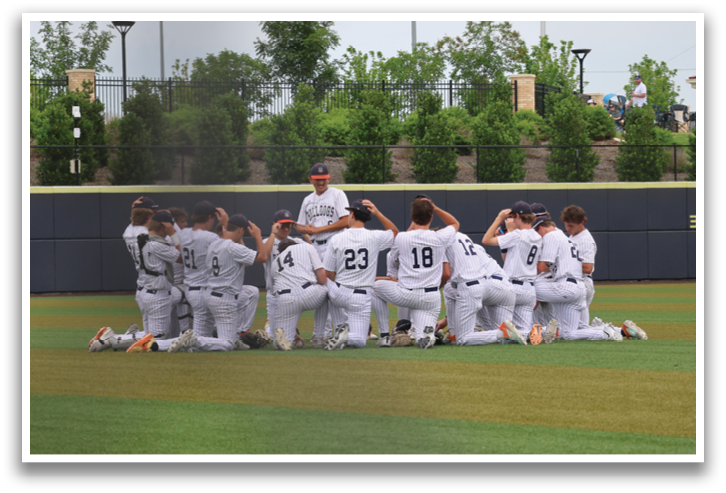 A group of baseball players are kneeling on the field, praying before a game. Contenido generado con IA
