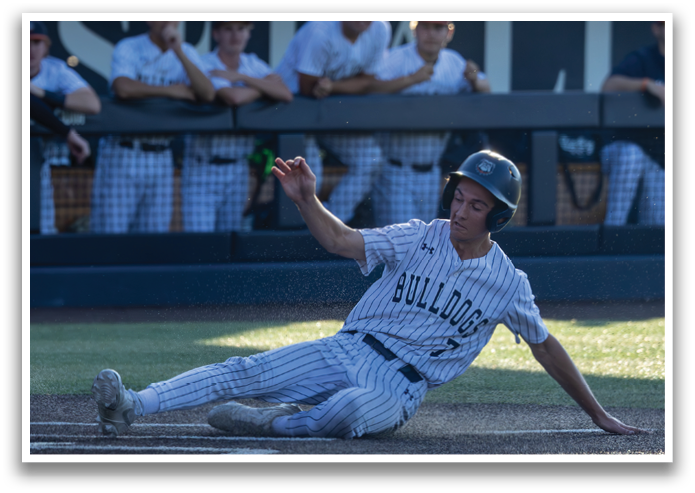 A baseball player slides into a base, wearing a helmet and a jersey. Contenido generado con IA
