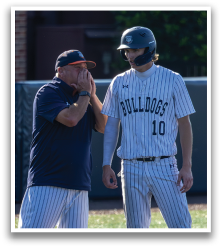 Two men on a baseball field, one wearing a helmet and the other talking to him. Contenido generado con IA