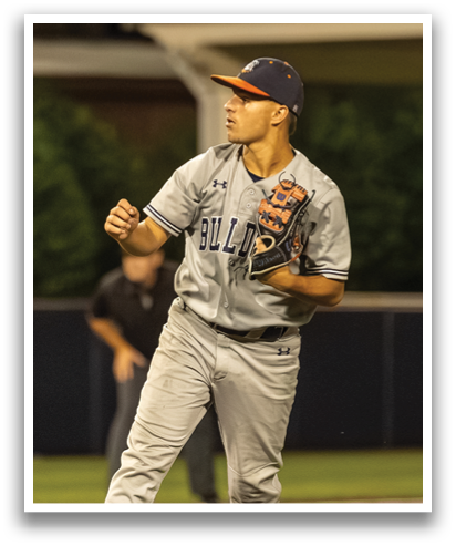 A baseball player in a grey uniform is on the mound, holding a baseball glove and preparing to throw the ball. Contenido generado con IA