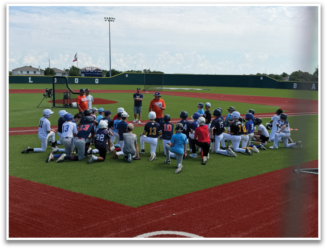 A group of baseball players are sitting on the field, listening to a coach. Contenido generado con IA