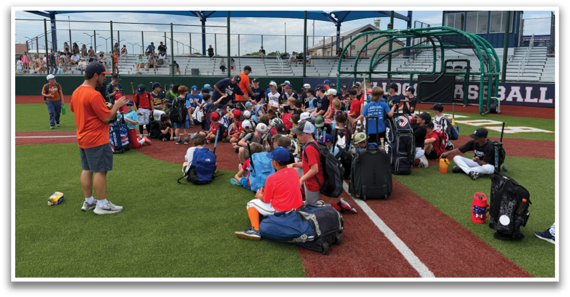 A group of people are sitting on the baseball field, with some sitting on the ground and others on chairs. There are several backpacks and a suitcase on the ground, and a baseball bat is visible. The scene appears to be a casual gathering or event taking place on the baseball field. Contenido generado con IA