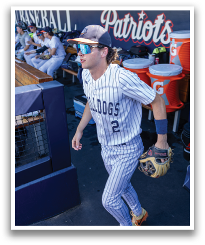 A baseball player wearing a blue and white uniform is walking on the field. Contenido generado con IA