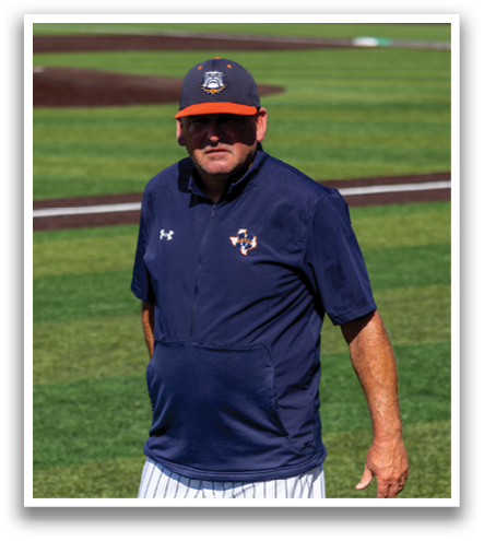 A man wearing a blue hat and a blue shirt is walking on a baseball field. Contenido generado con IA