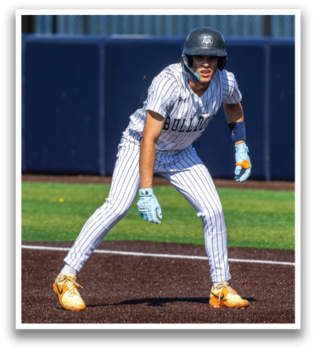 A baseball player wearing a black helmet and striped uniform is standing on the field. Contenido generado con IA