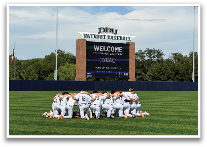Baseball players in white uniforms huddle on a field, some with their hands on their knees. Contenido generado con IA
