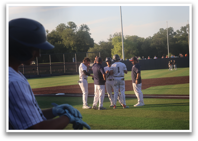 Baseball players on a field, some wearing blue and white uniforms, talking to each other. Contenido generado con IA