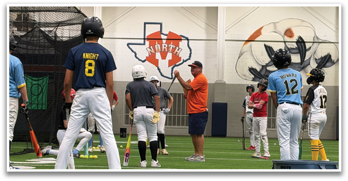 A group of young men are standing on a baseball field, some of them holding baseball bats. A man in an orange shirt is giving instructions to the group. Contenido generado con IA