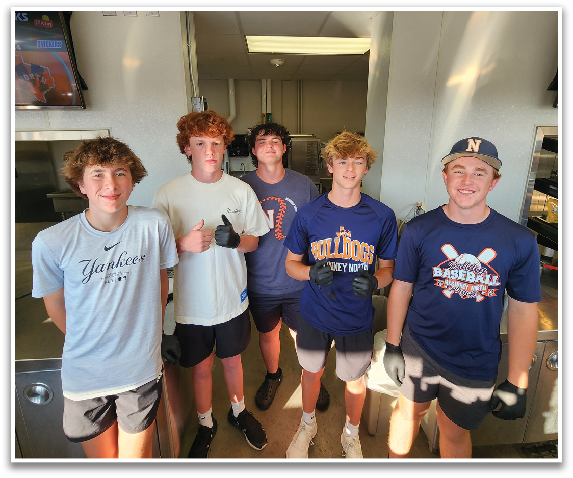 Five young men pose for a picture in a kitchen. Contenido generado con IA